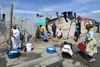 I fattige townships som Khayelitsha ved Cape Town er der i store områder ikke rindende vand og toiletter i blikhusene. Tøjvask foregår på gaden i baljer, og nu er beboerne begyndt at genbruge vandet til skyl i de fælles toiletter for at spare på det. Foto: Eric Miller