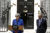 Premierminister Theresa May talte fredag foran Downing Street 10 i London med sin mand, Phlip, ved sin side. Hun orienterede om forløbet af sin audiens hos dronning Elizabeth II, hvor hun bad om lov til at danne en regering. Foto: Matt Dunham/AP