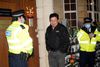 Myanmar's Ambassador to the United Kingdom, Kyaw Zwar Minn, stands with police officers locked outside the Myanmar Embassy in London on April 7, 2021. - Myanmar's ambassador in Britain on Wednesday said a Yangon miltary-linked figure had "occupied" the embassy in London, and that he was barred from accessing the building. "So this is kind of a coup, " ambassador Kyaw Zwar Minn told AFP outside the central London building, the scene of earlier protests, adding that "defence attache, they occupy my embassy". (Photo by Niklas HALLE'N / AFP)
