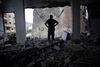 Mandag inspicerede palæstinensere i Gaza by ødelæggelserne efter nattens angreb. Foto: Khalil Hamra/AP