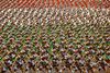 Medlemmer af Revolutionsgarden marcherer med små bannere, så de sammen udgør det iranske flag, under en militærparade foran ayatollah Khomeinis mausoleum uden for Teheran. Foto: Ebrahim Noroozi/AP