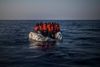 Afrikanske flygtninge og migranter i en punkteret gummibåd venter på hjælp i Middelhavet nord for Libyen. Arkivfoto: Santi Palacios/AP
