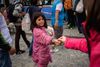 En lille migrant-pige får nogle mønter af en fastboende i München.